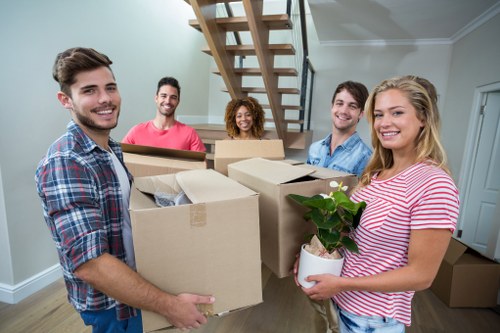 Professional moving helper loading boxes into a van
